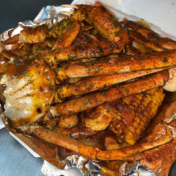 Krab Kingz seafood boil with crab legs, shrimp, and corn, seasoned with spices and herbs.